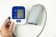 female hands check blood pressure monitor and heart rate monitor with digital manometer, isolated white background, healthcare and medical concept