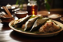 Rice Dumplings In Banana Leaf On Wooden Table, Closeup, Zongzi On The Plate On The Table, AI Generated