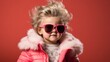 © Liana - Stylish little girl with wild hair wearing pink sunglasses and a winter jacket.