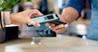 © HockleyMedia/peopleimages.com - Cashier, customer and phone for POS machine for restaurant fintech, digital payment and easy checkout services. Barista or people hands at point of sale counter with mobile app tap or scan at cafe