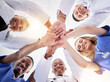 © Mia Bam/peopleimages.com - Hands, healthcare and a team of doctors in a huddle in the hospital together from below. Medical, diversity and solidarity with a medicine professional group standing in a circle in a clinic