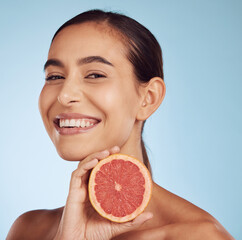 Wall Mural - Happy woman, skincare portrait and grapefruit for beauty, cosmetics, natural product and tropical facial or vitamin c. Face of person or model with red fruit for dermatology on studio blue background