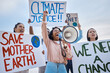 © K Davis/peopleimages.com - Black woman, climate change and megaphone protest with crowd protesting for environment and change. Save earth sign, group activism and angry people shouting on bullhorn to stop planet pollution.