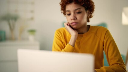 Sad serious woman freelancer programmer thinking having difficulties coding creating apps on laptop. Focused african american girl try to solve problem looks at screen. Remote distant freelance work.