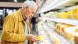 © kalafoto - A man is shopping for cheese in a supermarket