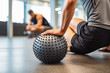Close up shot of a caucasian athletic man using a spiky massage ball after work out for relaxing muscles, sport massage