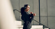 © HockleyMedia/peopleimages.com - Runner girl, headphones and stretching arms on stairs for music, vision and ideas in city, workout and training. Woman, thinking and listen on steps with streaming subscription, wellness and warm up