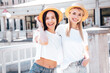 Two young beautiful smiling hipster female in trendy summer white t-shirt and jeans clothes. Carefree women posing in the street. Positive models having fun outdoors. Cheerful and happy. In hat