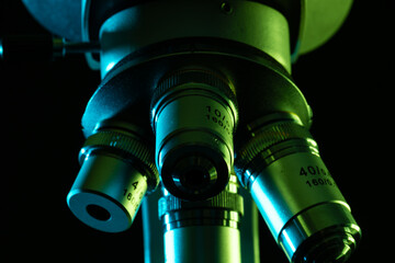 Poster - Close up of laboratory microscope and copy space on black background