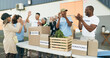 © N Felix/peopleimages.com - Volunteer, celebration and people with box for donation, charity drive and community service. Collaboration, volunteering and excited men and women clapping for success in NGO, recycle and teamwork