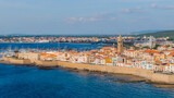 Fototapeta Desenie - Aerial view of the old town of Alghero in Sardinia. Photo taken with a drone on a sunny day. Panoramic view of the old town and harbor of Alghero, Sardinia, Italy.