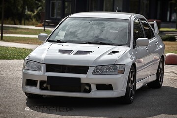 Wall Mural - White car on a street background. Modern city sport car with a spoiler wallpaper