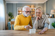© Miljan Živković - senior couple at home woman check blood pressure husband sit beside