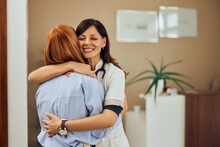 Focus On The Brunette Doctor, Hugging Her Patient, Looking Happy, Just Finished The Appointment.