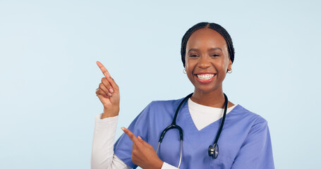 Wall Mural - Black woman, nurse and pointing at medical information, list or announcement with smile in portrait on blue background. Healthcare news, advertising and mockup for health alert and about us in studio