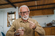 © Miljan Živković - senior man caucasian grandfather take drug tablet drink painkillers
