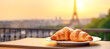 A delectable French croissant, a popular breakfast pastry, is served fresh and warm at a cozy cafe, making for a delightful and tasty start to the morning.