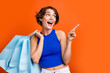 canvas print picture - Portrait of attractive impressed girl hold store bags look direct finger empty space advert isolated on orange color background