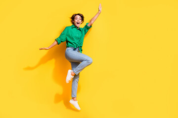 Sticker - Full length photo of cheerful pretty lady wear green shirt jumping high having fun empty space isolated yellow color background