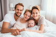 © Irina - a Happy Family with a newborn baby, lying on a light bed in a very bright room