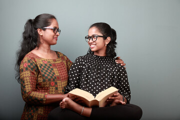 Wall Mural - Indian ethnic affectionate mother helps the daughter in her studies