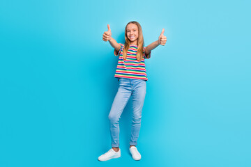 Poster - Full length photo of good mood schoolgirl dressed striped t-shirt jeans showing thumbs up to you isolated on blue color background