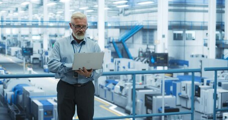 Poster - Senior Factory Manager Working on Laptop at a Futuristic Industrial Manufacture with Autonomous AI Robots. Specialist Monitoring All the Data on a Computer, Checking Reports and Planning Workload