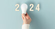 canvas print picture - Energy saving lamp in woman's hand. Energy saving in new year concept.
