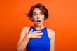 © deagreez - Photo of funky shocked lady wear blue singlet open mouth arm chest isolated orange color background