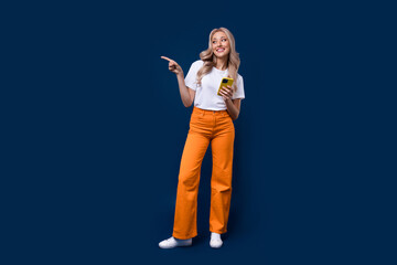 Poster - Full length photo of lovely glad stylish girl presenting empty space modern technology store isolated on dark blue color background