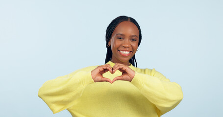 Canvas Print - Portrait, heart and hands of black woman in studio for love, kindness or charity donation on blue background. Happy model show finger sign of hope, care or thank you emoji for support, review or vote