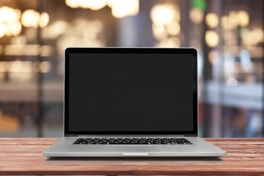 Laptop with a blank screen on table in cafe