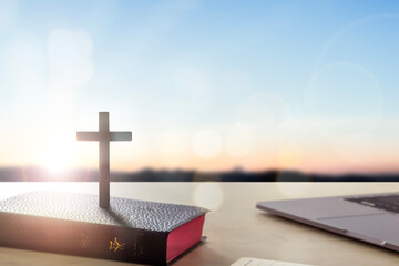 Wall Mural - silhouette wooden cross on holy bible sunrise background