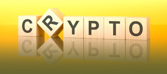 Wall Mural - crypto text on wooden blocks on a yellow table. light background. Cryptocurrency stock market concept.
