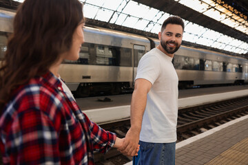 Wall Mural - Long-distance relationship. Couple walking on platform of railway station