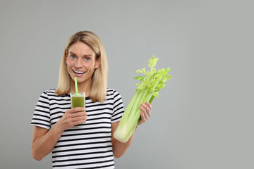 Canvas Print - Happy woman holding glass with tasty celery juice and fresh vegetable on light grey background. Space for text