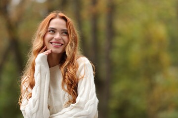 Wall Mural - Autumn vibes. Portrait of smiling woman outdoors. Space for text