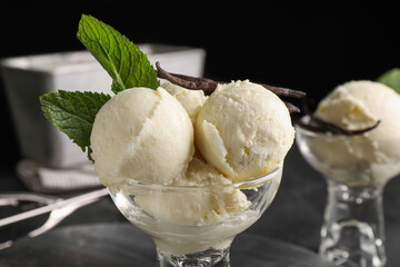 Wall Mural - Tasty ice cream with vanilla pods and mint in glass dessert bowl on table, closeup