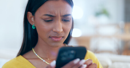 Sticker - Confused, doubt and woman networking on a phone on sofa in the living room reading bad news. Upset, mad and young Indian female person scroll on social media or the internet with cellphone at home.