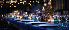 Elevated Rooftop Dinner Tables Adorned With Gray And Blue Cloths Porcelain Blue Glasses And Ornate Flower Arrangements Accentuated By Bokeh Lights In The Background