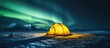 © Lasvu - Winter field with an incredible starry sky backdrop showcases a yellow tent illuminated from within alongside the mesmerizing Aurora borealis