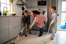 Joyful Family Spending Quality Time Cleaning Their Modern Kitchen Together