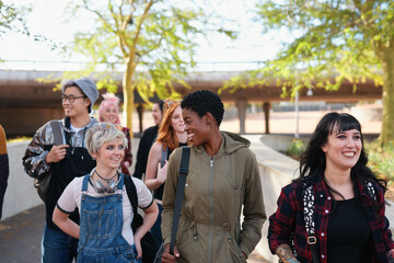 College, campus and group of students walking at university talking and speaking with diversity ready for learning. Happy, education and young gen z people or friends with a scholarship together