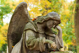 Fototapeta Paryż - Historic Statue on the autumn mystery old Prague Cemetery, Czech Republic