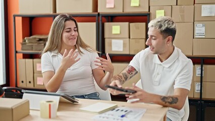 Wall Mural - Two workers man and woman using laptop hugging each other celebrating at office