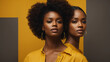 Beauty styled studio shot of two African - American women wearing yellow blouses on yellow gray background