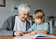 © Lumos sp - grandchild family child grandparent grandmother book reading elderly grandson boy happy together read learning education