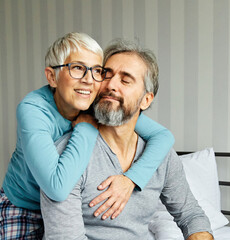 Wall Mural - couple senior bed woman man home wife husband love together elderly caucasian adult happy retirement mature male old bedroom smiling resting retired aged relaxation leisure lying relationship