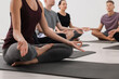 © New Africa - Group of people practicing yoga on mats indoors, closeup