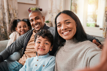 Selfie, mother and father with children in portrait, happy people at family home with bonding and love in living room. Relax on sofa together, parents and young kids with smile in picture for memory